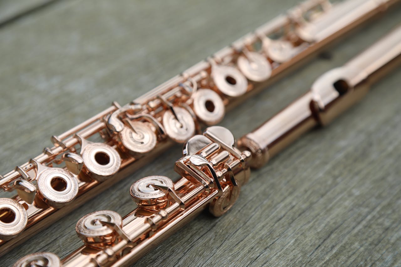 Detailed close-up of a flute resting on a wooden surface, showcasing intricate keys.
